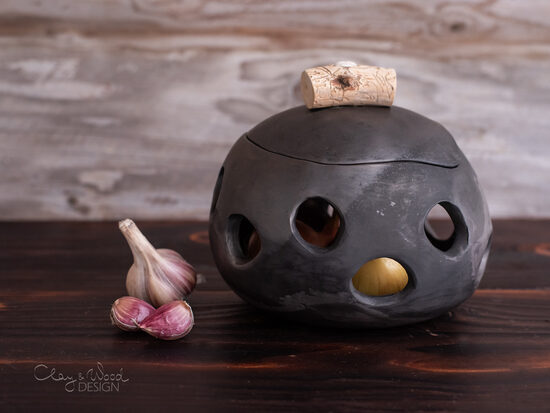 Melnās keramikas trauks ar caurumiem