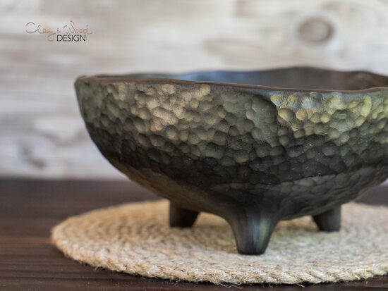 Melnās keramikas trauks ar faktūru uz kājām