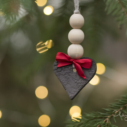 Black ceramic heart with wooden beads and red ribbon. Christmas tree decors.