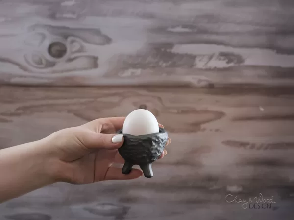 black pottery egg cup on legs