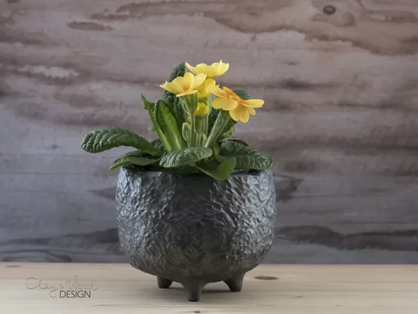 Textured black pottery pot on legs